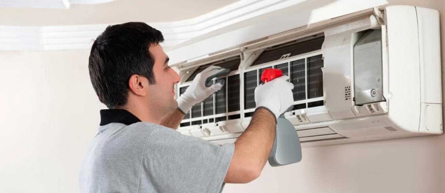 HVAC professional cleaning an air conditioner