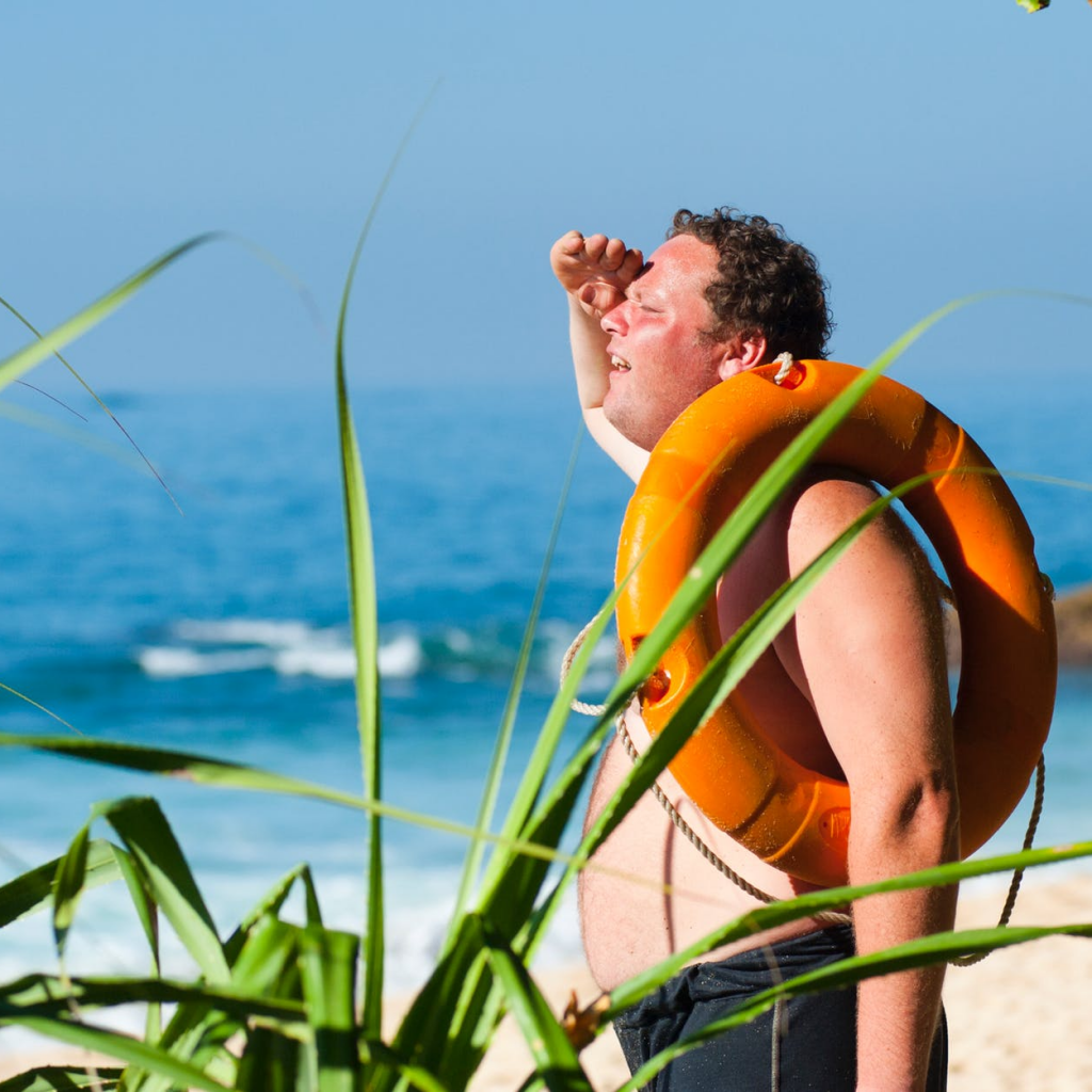 Image of a man standing on a beach in the hot weather. Make sure you buy an air con that aligns with your needs so you stay cool in summer. 