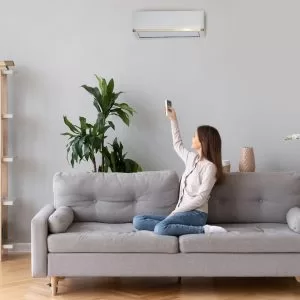 Woman turning on an air conditioner